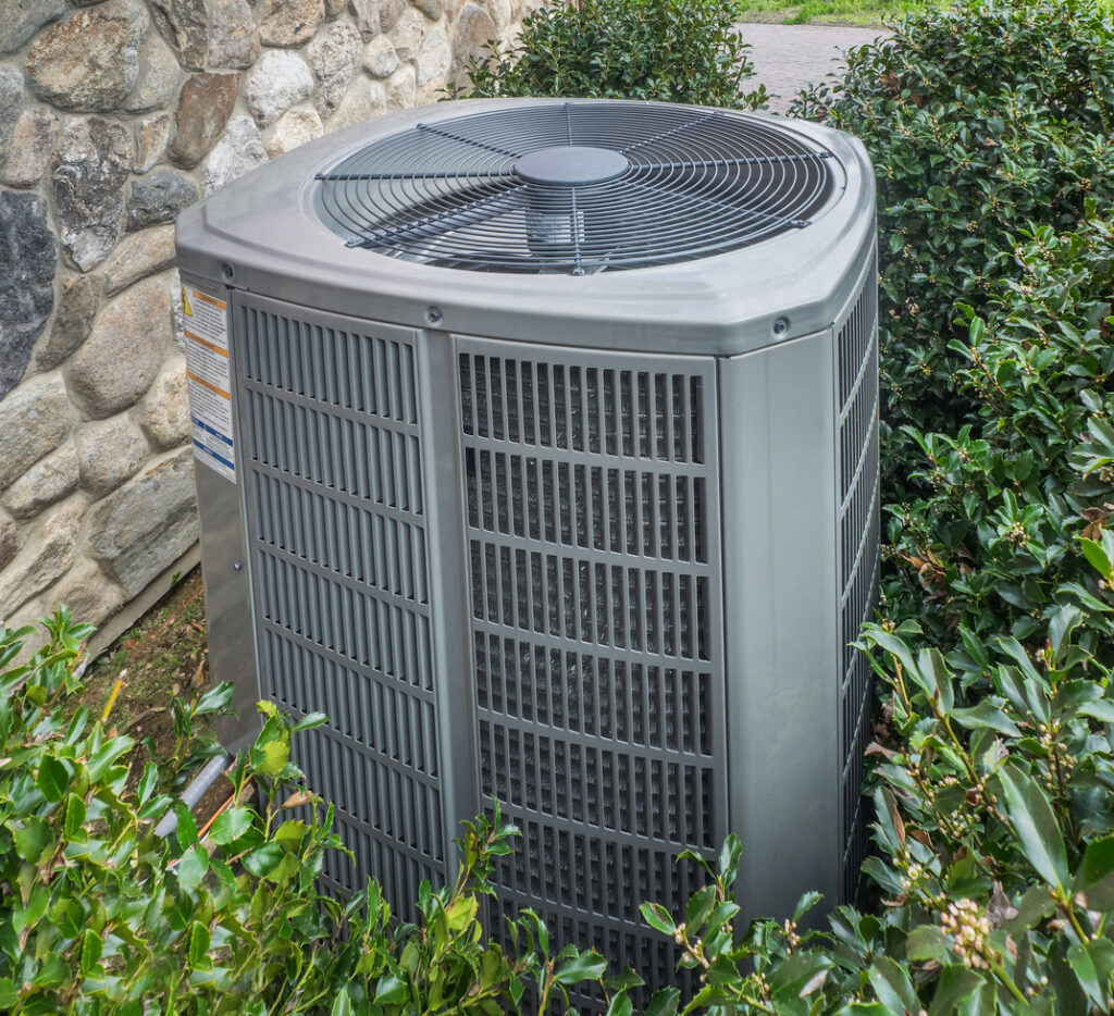 Heat pump unit behind a house.